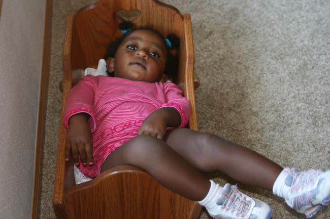 baby in a doll crib